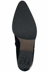 Černá nazouvací bota s špičatou špičkou a strukturovaným svrškem, hladká kožená podešev. Obsahuje embosované logo na podrážce a elegantní, štíhlý design.