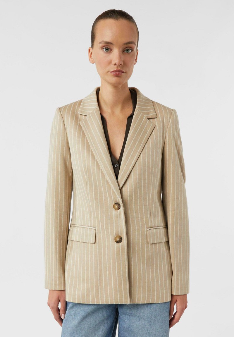 Beiger gestreifter Blazer mit Reverskragen, zwei Fronttaschen und zwei Knöpfen. Akzentuiert durch schmale weiße Streifen und eine strukturierte Passform.