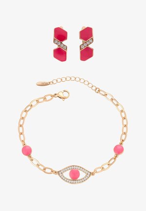 Złota bransoletka z różowymi okrągłymi kamieniami i wzorem oka wysadzanego kryształami, w zestawie ze złotymi i różowymi geometrycznymi kolczykami z kryształami.
