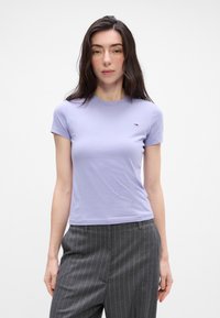 Kortærmet lavendel t-shirt i blødt bomuld med rund hals og lille logo detalje. Sæt sammen med grå stribede bukser.