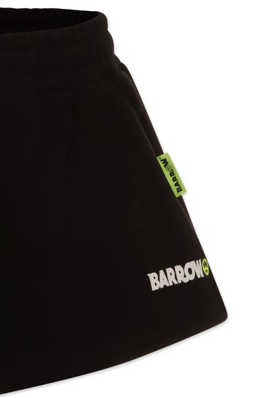 Gonna sportiva nera con vita arricciata, caratterizzata da un logo bianco "BARROW" e un'etichetta verde brillante sul lato. Texture liscia, design informale.