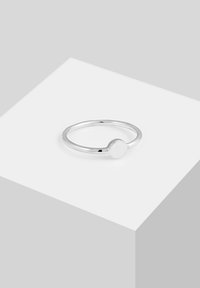 Inel metalic argintiu cu un band subțire și un disc rotund, neted în partea de sus, având un finisaj lustruit și un design minimalist.