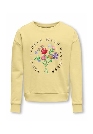 Felpa giallo chiaro con fiori ricamati colorati e la frase "Tratta le persone con gentilezza" in un disegno circolare sul davanti.