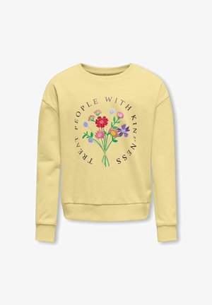 Světlounce žlutá mikina s barevnými vyšívanými květinami a nápisem "Chovejte se k lidem s laskavostí" v kruhovém designu na přední straně.