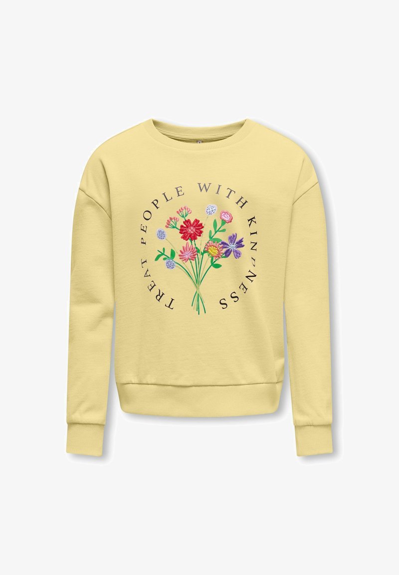Sweat-shirt jaune clair avec des fleurs brodées colorées et la phrase « Traitez les gens avec gentillesse » en design circulaire sur le devant.