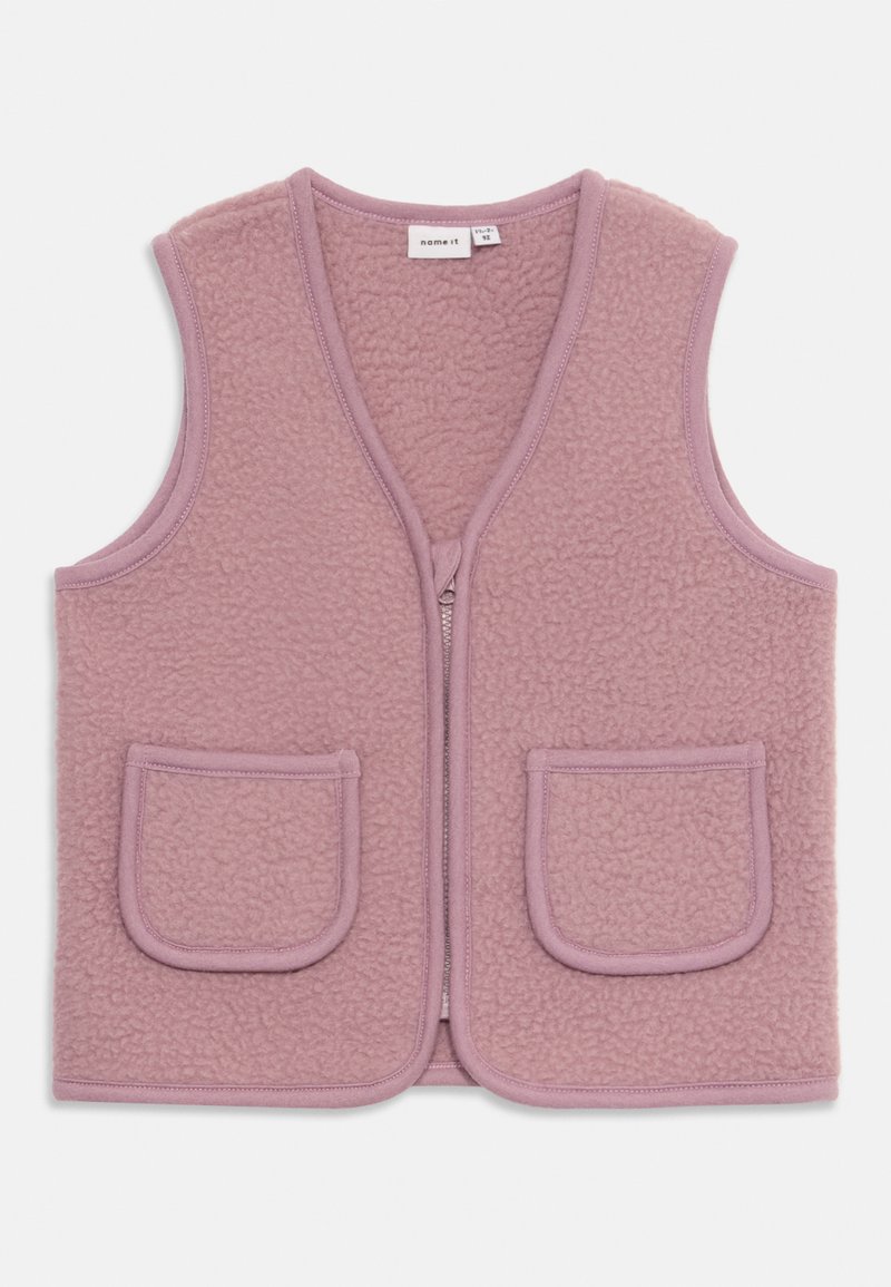 Fleecasta jopica v mehki roza barvi, z V-izrezom, sprednjim zadrgo in dvema velikima žepoma. Tekstura površine z našitimi robovi.