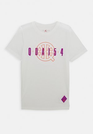Maglietta bianca con scritta "PARIS" viola e arancione e logo da basket sulla parte frontale, e una piccola toppa con logo viola vicino all'orlo.