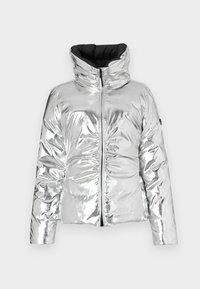 Casaco puffer prateado com uma superfície brilhante e refletora, gola alta, fecho através de zíper e textura em matelassé. Acentuado com interior preto.