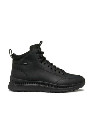 Zapatillas de caña alta negras, hechas de material sintético suave, con una suela de goma texturizada, punta redonda y cierre de cordones con ojales de metal.