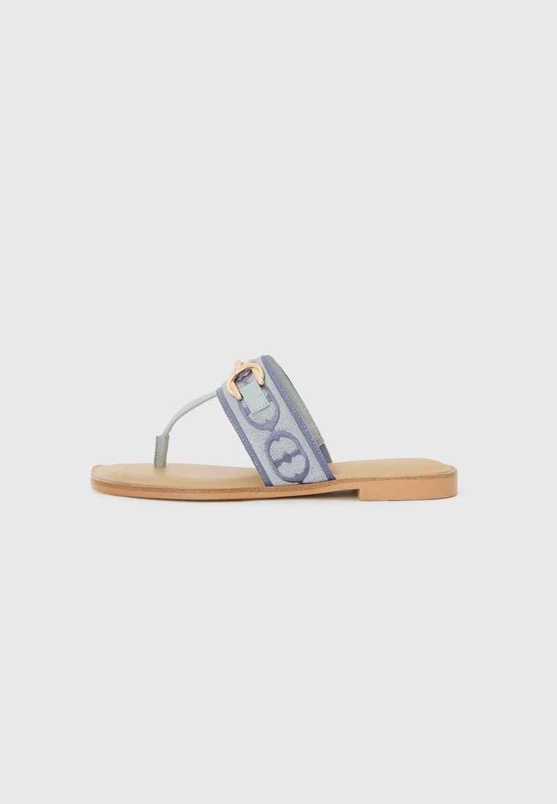 Sandali piatti con fascia in tessuto azzurro chiaro decorata con motivi circolari, una fibbia dorata e una suola color beige chiaro.