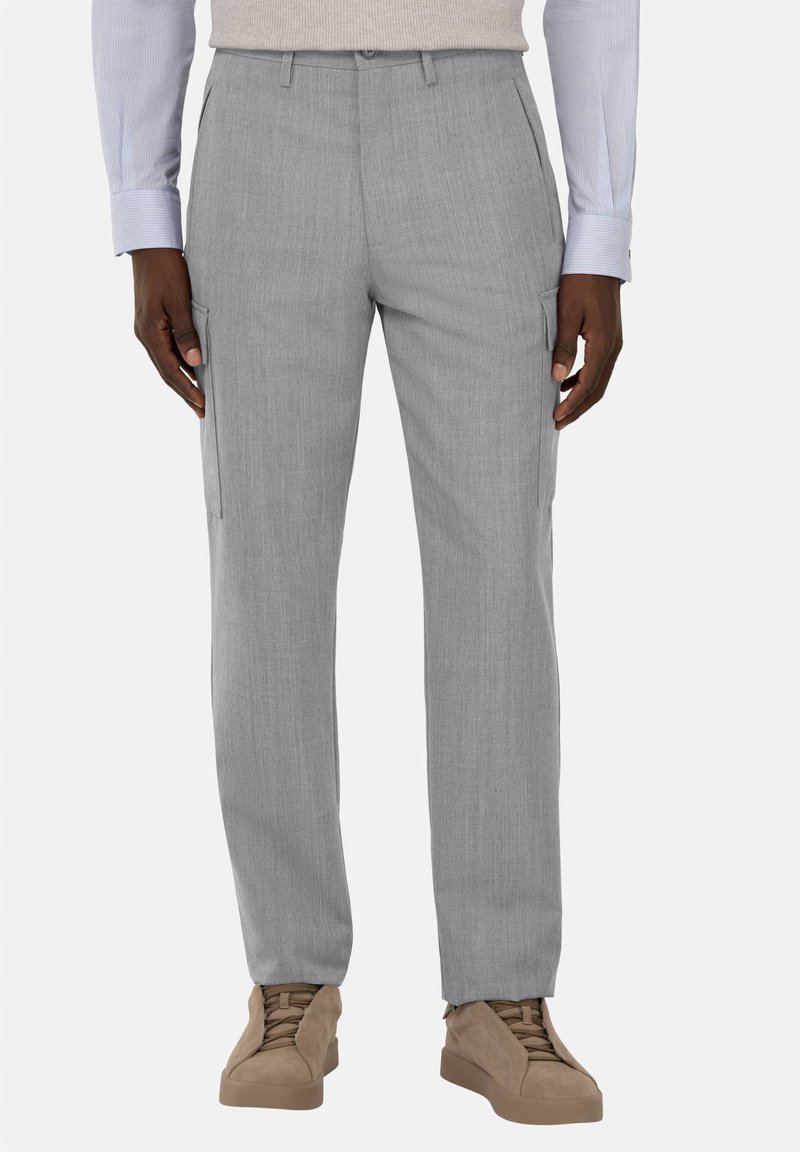 Szare spodnie cargo z teksturowanej tkaniny, slim fit, z bocznymi kieszeniami i płaskim przodem. Zestawione z jasnobrązowymi trampkami dla kontrastu.
