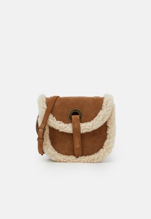Brown suede crossbody bag with cream shearling trim and adjustable strap, featuring a circular metal clasp on the front flap.