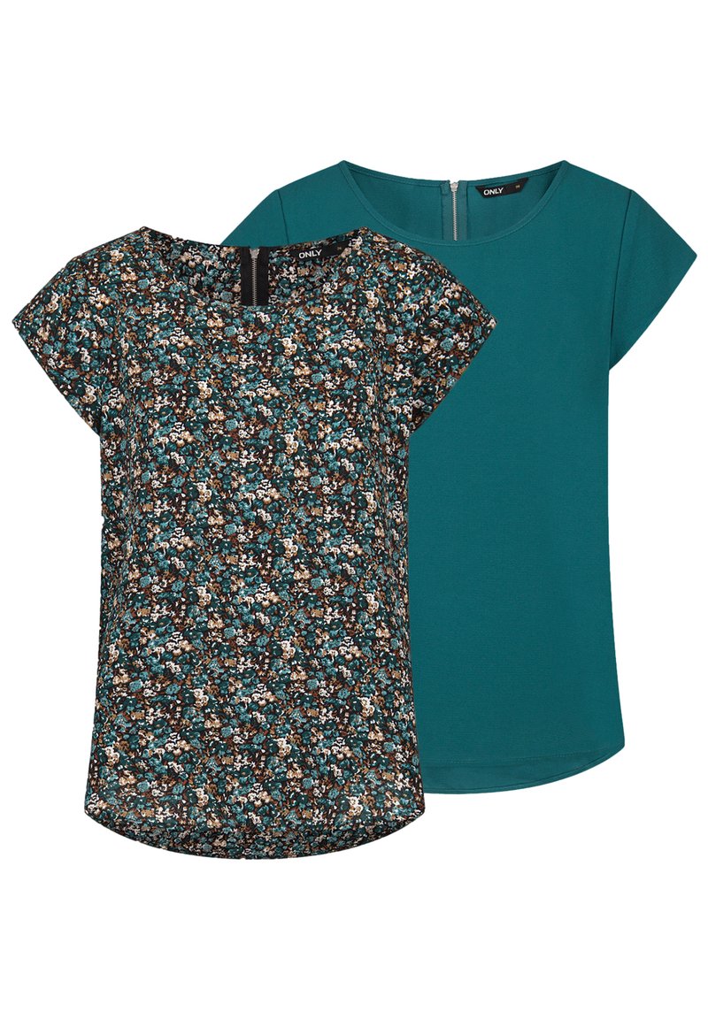 Haut à manches courtes avec un motif floral en teal, marron et crème d'un côté ; couleur unie teal au verso ; tissu léger.