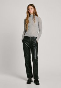 Harmaa ribatty turtleneck-toppi ja mustat nahkaiset suorat housut. Asusteessa on tiukka muotoilu, jossa on sileä tekstuuri ja vähäiset yksityiskohdat.