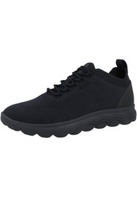 Czarne buty sportowe z oddychającą dzianiną, teksturowanym wzorem, zaokrąglonym noskiem, grubą falistą podeszwą oraz wzmocnioną pętelką na pięcie ułatwiającą zakładanie.