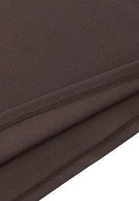 Ciemnobrązowa tkanina o gładkiej fakturze, z płaskimi szwami i podwiniętym brzegiem, co wskazuje na miękki, elastyczny materiał.