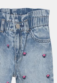 Džínové kraťasy v světle modré barvě s indigo a růžovým vzorem mašlí. Mají knoflíkové zapínání a elastický pas. Jemně strukturovaná látka.