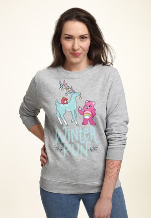 Grå sweatshirt med et grafisk motiv af en blå rensdyr og en pink bjørn med teksten "VINTER SJOV." Sat mod en lys baggrund.