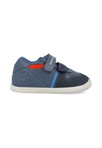 Zapato infantil en azul y marino con una correa de Velcro, cuero texturizado, acentos en rojo y azul contrastantes, y una suela de goma blanca.