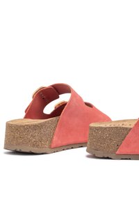 Sandali in suede corallo con zeppa in sughero, dotati di lati intagliati e soletta sagomata. La suola è testurizzata per una migliore presa.