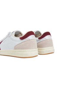 Λευκά αθλητικά παπούτσια με βυσσινί σουέντ λεπτομέρειες, υφασμάτινες μπεζ επιφάνειες και καουτσούκ σόλα. Διαθέτουν την εγκοπή "1973" στο πίσω μέρος.