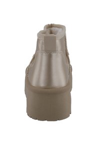 Beige enkellaars met een soepel leren bovenwerk, elastische zijkanten, een zacht interieur en een dikke rubberen zool met een gestructureerd patroon.