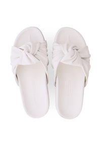 Weiße Slip-On-Sandalen mit gedrehten Stoffriemen und konturierten Fußbetten, von oben auf einem weißen Hintergrund gezeigt.