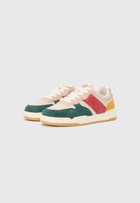 Sneaker multicolori con pannelli in suede verde, rosa, rosso e giallo, lacci crema e suola in gomma texture. Design classico a taglio basso.
