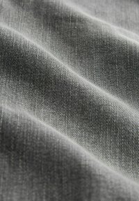 Gråt stof med en tekstureret vævning, der viser subtile variationer i skygge og lys, der fremhæver materialets bløde, holdbare kvalitet.