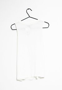 Top blanco sin mangas colgado de un gancho negro; hecho de una tela ligera con un escote curvado y un dobladillo sutilmente redondeado.