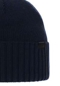 Beanie blu navy lavorato a maglia con texture a coste e una sottile etichetta del logo nera sul lato. Materiale morbido, progettato per calore e comfort.