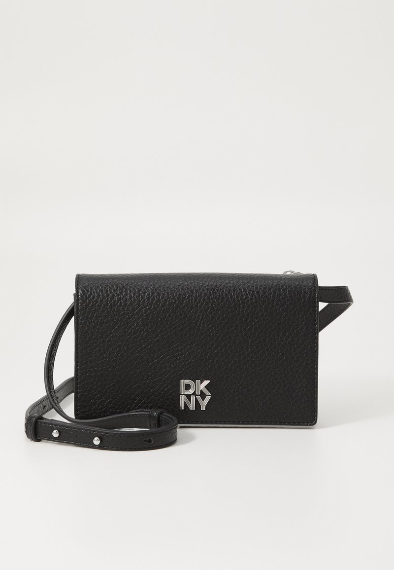 Musta nahkristcrossbody kott, millel on kivine tekstuur, klapiga sulgemine ja hõbedane DKNY logo. Kaasas on eemaldatav rihm.