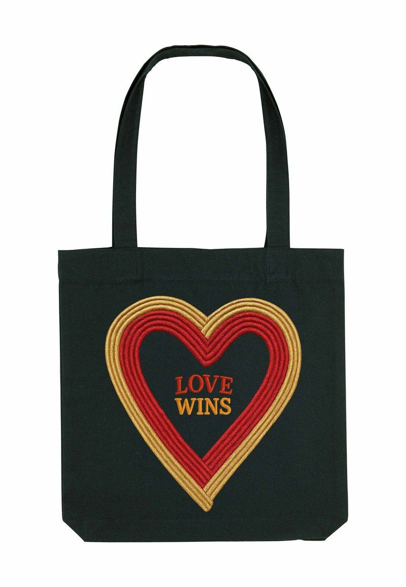 Zwarte canvas tote bag met een groot, rood en goud geborduurd hart ontwerp. Gecentreerde tekst leest "LOVE WINS" in oranje. Stevige handvatten.