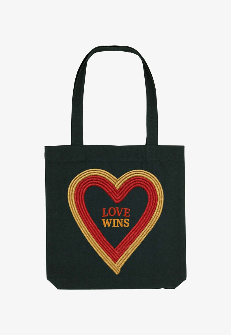 Zwarte canvas tote bag met een groot, rood en goud geborduurd hart ontwerp. Gecentreerde tekst leest "LOVE WINS" in oranje. Stevige handvatten.