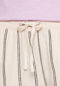 Ljusfärgade byxor i linneblandning med vertikala svarta ränder och dragsko i midjan, med en mjuk textur och avslappnad passform.