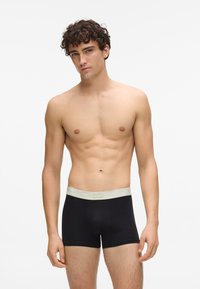 Boxeri negri cu talie elastică gri deschis, având un croi cu talie medie și textură moale. Talie elastică cu branding în față.