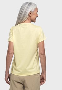 Gelbes T-Shirt mit kurzen Ärmeln aus weichem Stoff, mit klassischem Rundhalsausschnitt und lockerer Passform, umgeschlagenen Ärmeln und glatter Textur.