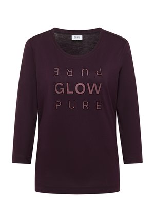 Fioletowa koszula z długim rękawem od CECIL z okrągłym dekoltem i napisem "GLOW PURE" w metalicznych akcentach z przodu. Miękka tkanina.