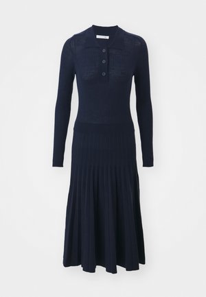 Abito a coste in navy con colletto, caratterizzato da una pattina con bottoni, maniche lunghe e gonna plissettata per una silhouette aderente.