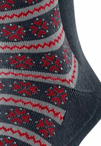 Stricksocken mit einem gemusterten Design, das Schneeflocken in Rot und Grau vor einem dunkelblauen Hintergrund zeigt; gerippte Textur und Knöchelhöhe.