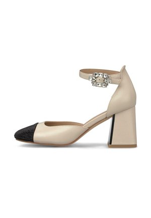 Zapato de cuero beige con una puntera de cuentas negras, correa en el tobillo con una hebilla de strass y un tacón bloque con un acento negro.