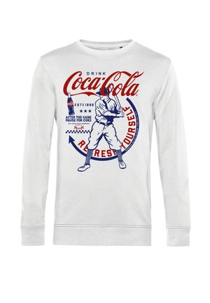 Biała, długosleeve koszula z grafiką baseballisty z vintage Coca-Coli, obrazem butelki oraz tekstem promującym orzeźwienie z Coke po meczu.