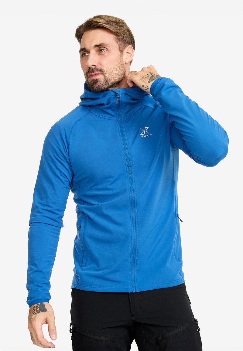 Blå zip-up hoodie med en fitted design, lättviktig tyg, långa ärmar och en huva. Har en logotyp på bröstet och fickor med dragkedja på sidan.