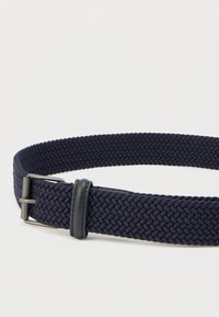 Cinturón tejido de tela azul marino con diseño trenzado, que presenta un detalle de cuero y una hebilla metálica para sujetar; ligero y flexible.