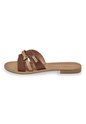 Sandale plate en cuir marron avec des brides croisées et une petite étiquette sur une bride, semelle intérieure beige et semelle basse en bois.
