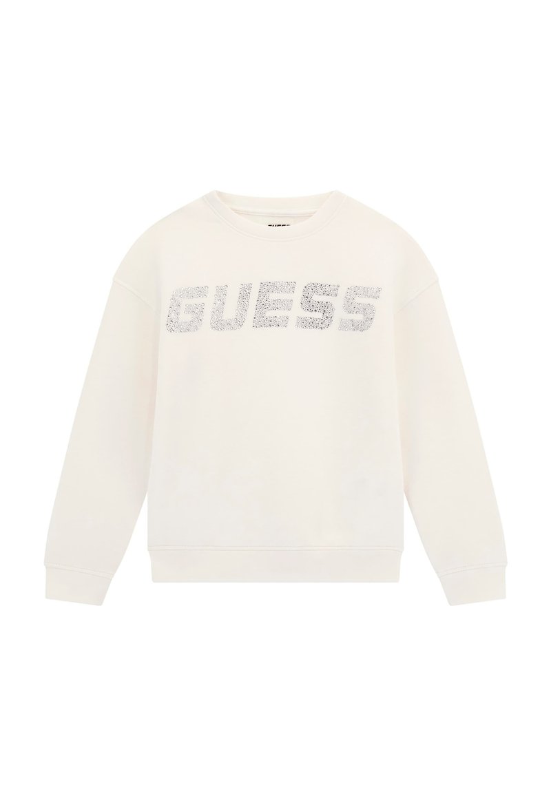 Sweatshirt crème avec un col rond et des manches longues. Présente un logo "GUESS" argenté bien visible sur le devant. Texture de tissu douce.