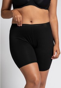 Shorts neri elasticizzati, tessuto morbido, design aderente, lunghezza a metà coscia, bordi senza cuciture, adatti per essere indossati sotto i vestiti.