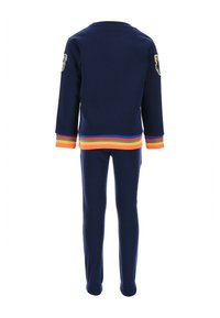 Marineblauer Trainingsanzug mit Rundhalsausschnitt, langen Ärmeln und elastischen Bündchen. Bunte Streifenakzente an den Bündchen und am Taillenbund. Bestickter Aufnäher an der Schulter.