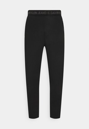 Leggings de algodón negros con un diseño ajustado, cinturilla elástica con la marca 'Calvin Klein Jeans' y una textura suave y elegante.