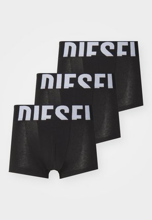 Boxer da uomo neri con una larga cintura bianca su cui è stampato in modo evidente "DIESEL". Tre pezzi esposti insieme. Texture liscia.
